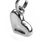 Sterling silver heart charm with thumb print design, hanging on a chain.