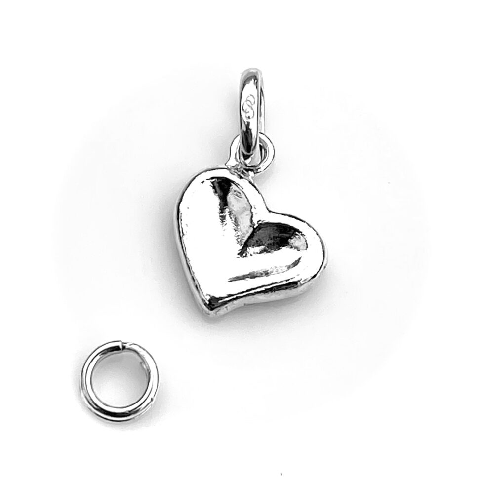 Sterling silver heart charm with thumb print design, hanging on a chain.