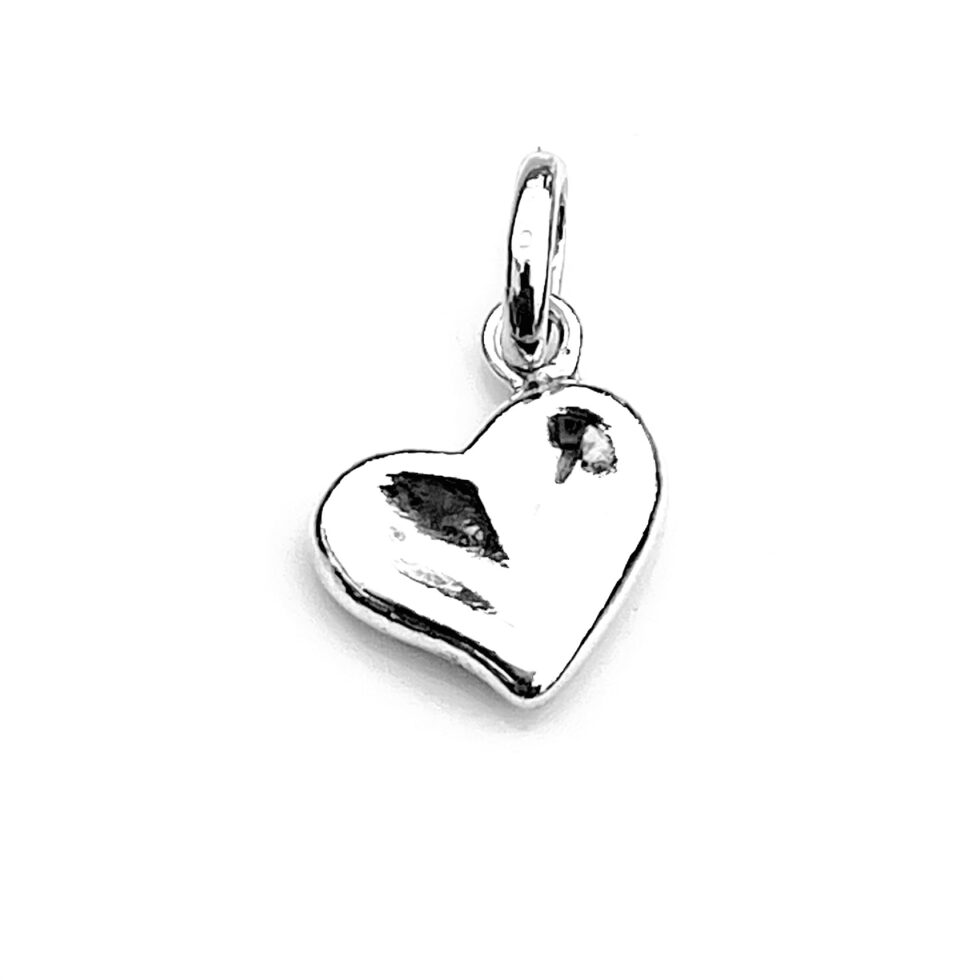 Sterling silver heart charm showing off thumbprint design and polished finish.