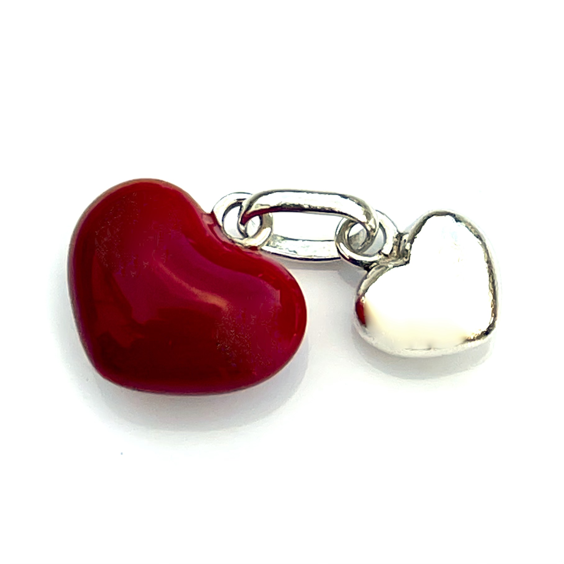 Vintage red enamel heart and silver charm close-up with a professional polish.