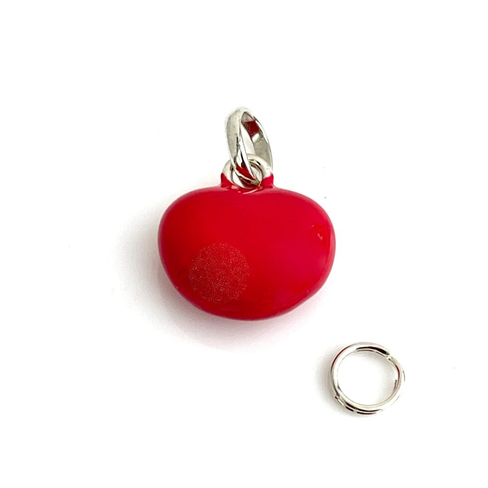 Close-up of the red enamel heart charm showing texture and shine