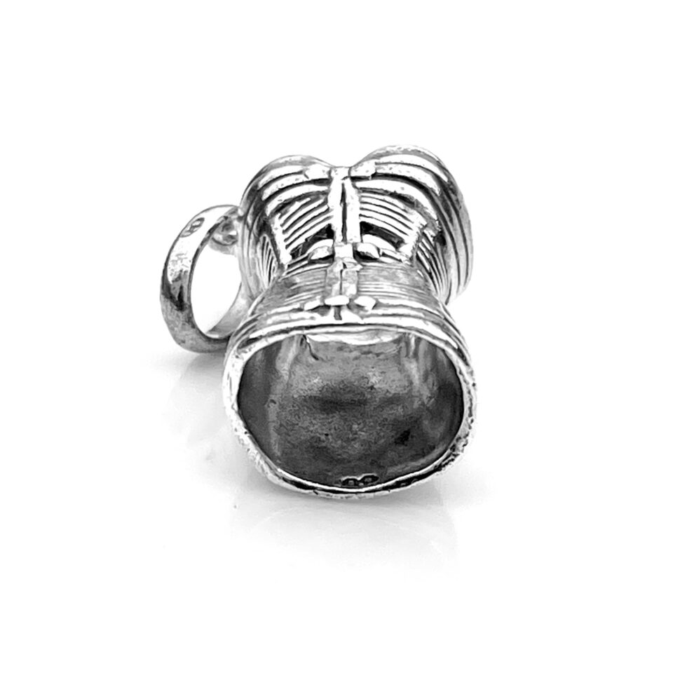 The charm’s polished finish photographed in natural light