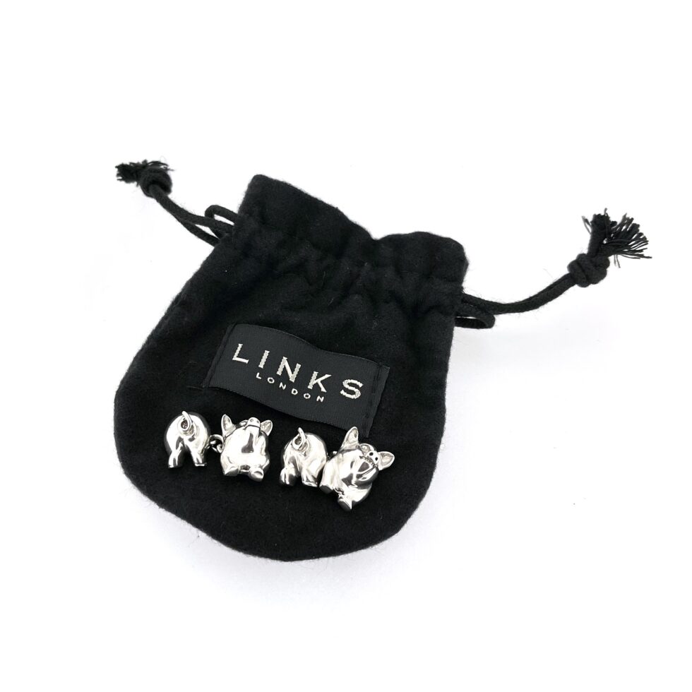 drawstring pouch of the 1994 Links of London Pig Cufflinks showing the polished front and back pig sections.