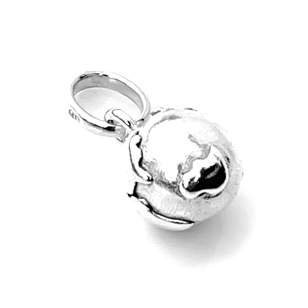 Close-up of the charm’s polished silver surface and globe silhouette.