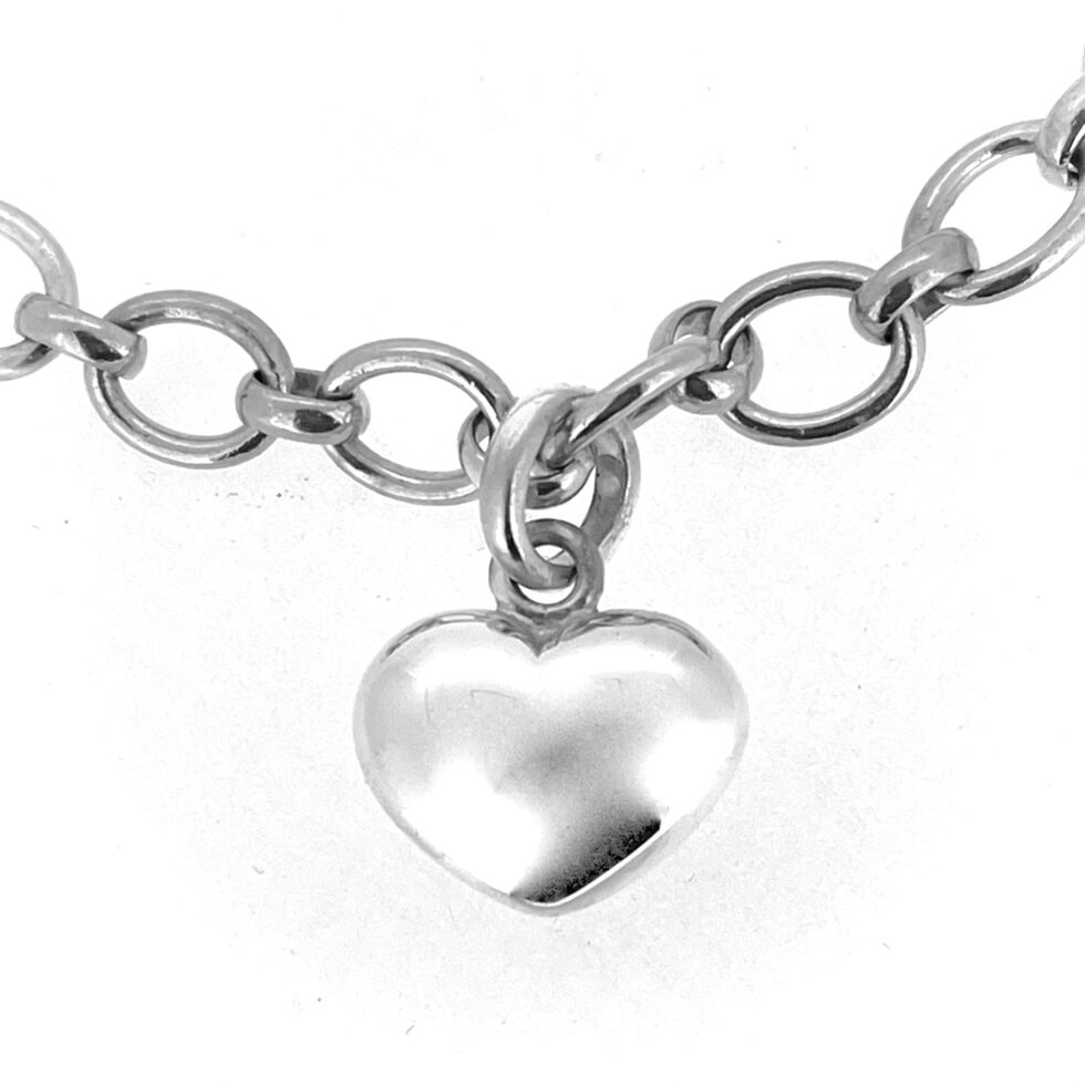 The heart charm shown in close-up, highlighting its polished surface.