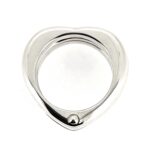 Angled shot capturing the bold, polished surface and intricate heart motif.
