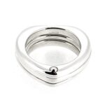 The ring displayed on a white background, highlighting its statement heart design.