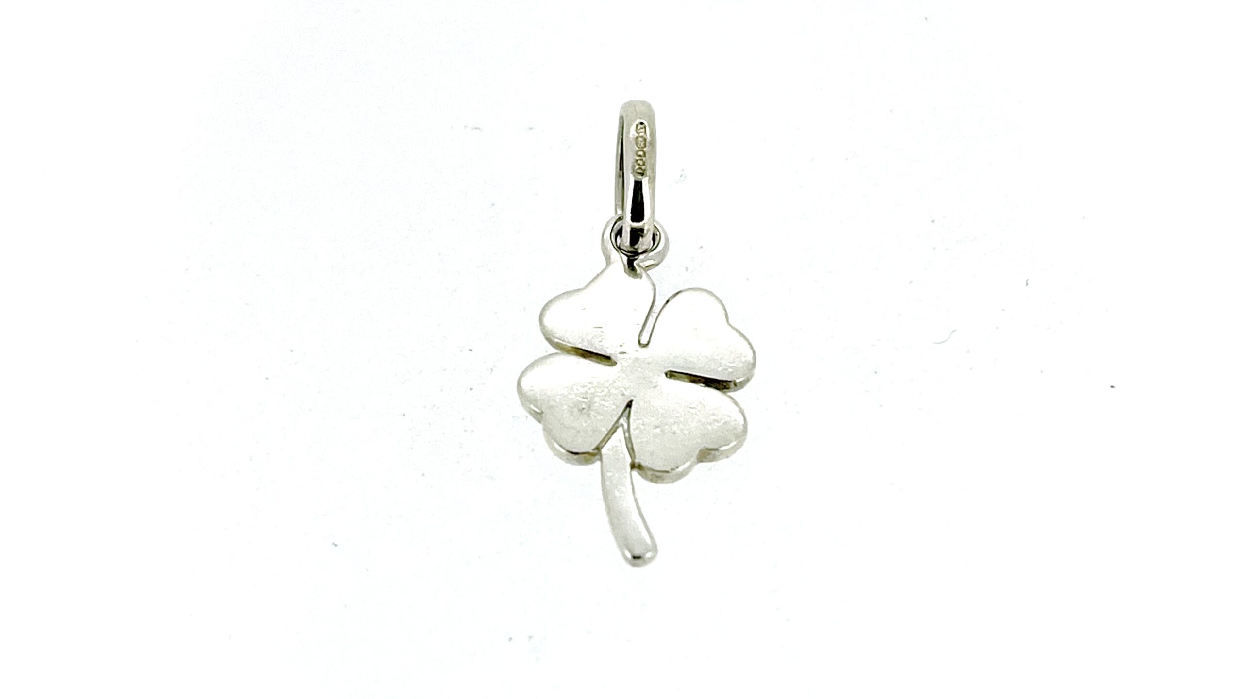 Vintage Links of London Four Leaf Clover Charm before restoration in a light box