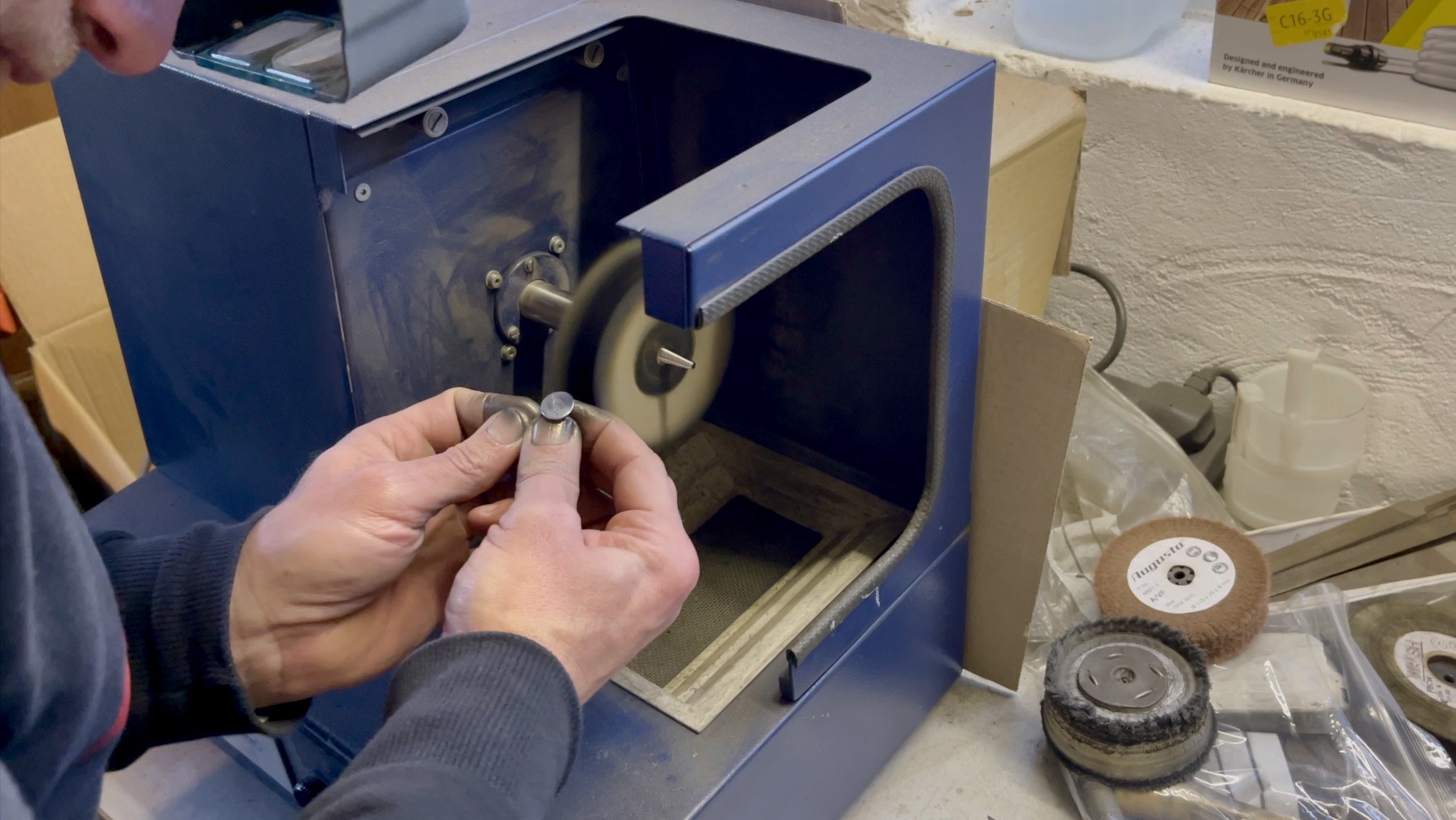 Jeweller hand-polishing Concord cufflinks on a polishing machine