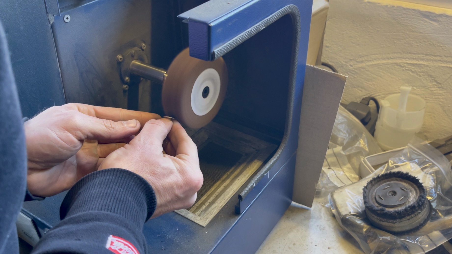 Jeweller hand-polishing Concord cufflinks on a polishing machine