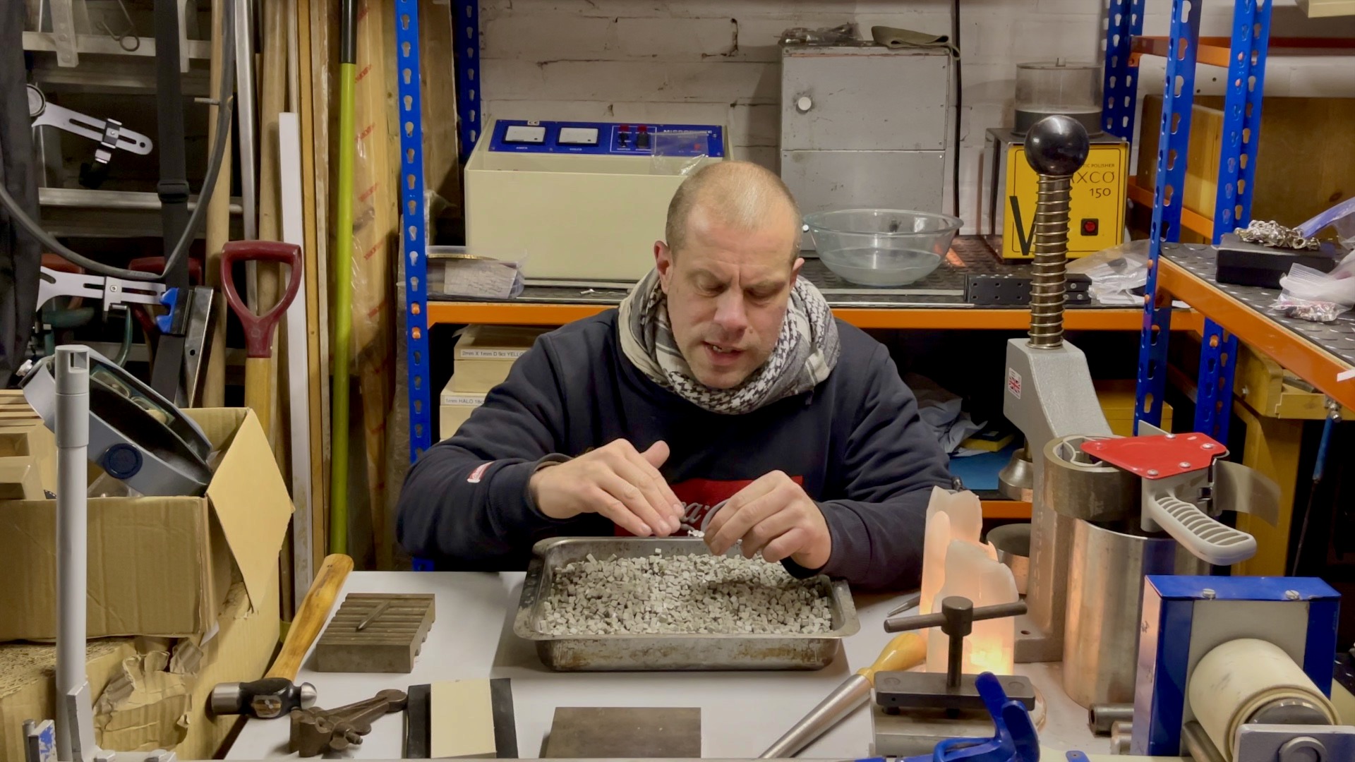 Jeweller inspecting the charm under magnification before further polishing.