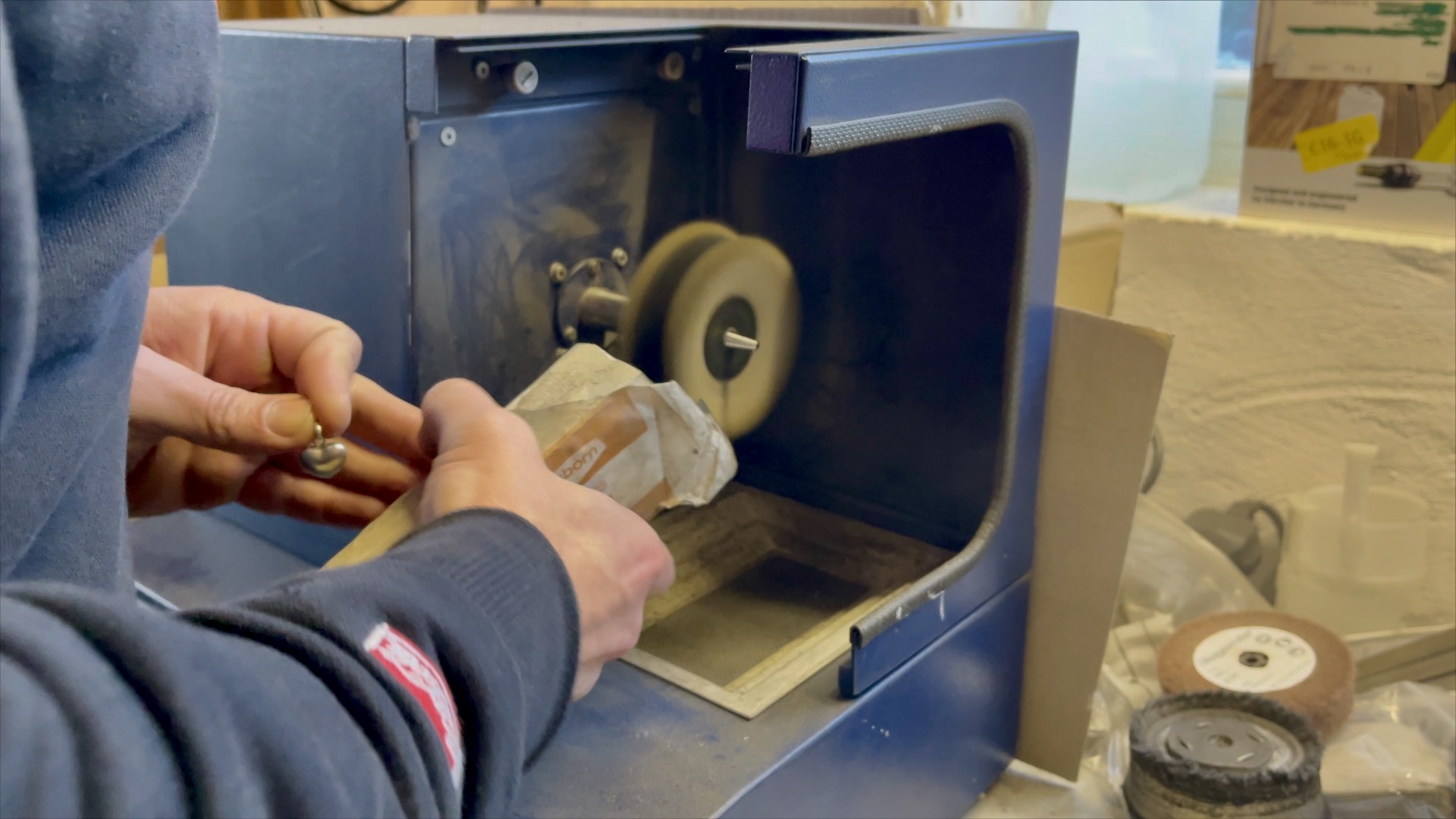 A jeweler using a soft mop and Hyfin polishing compound to achieve a mirror finish.