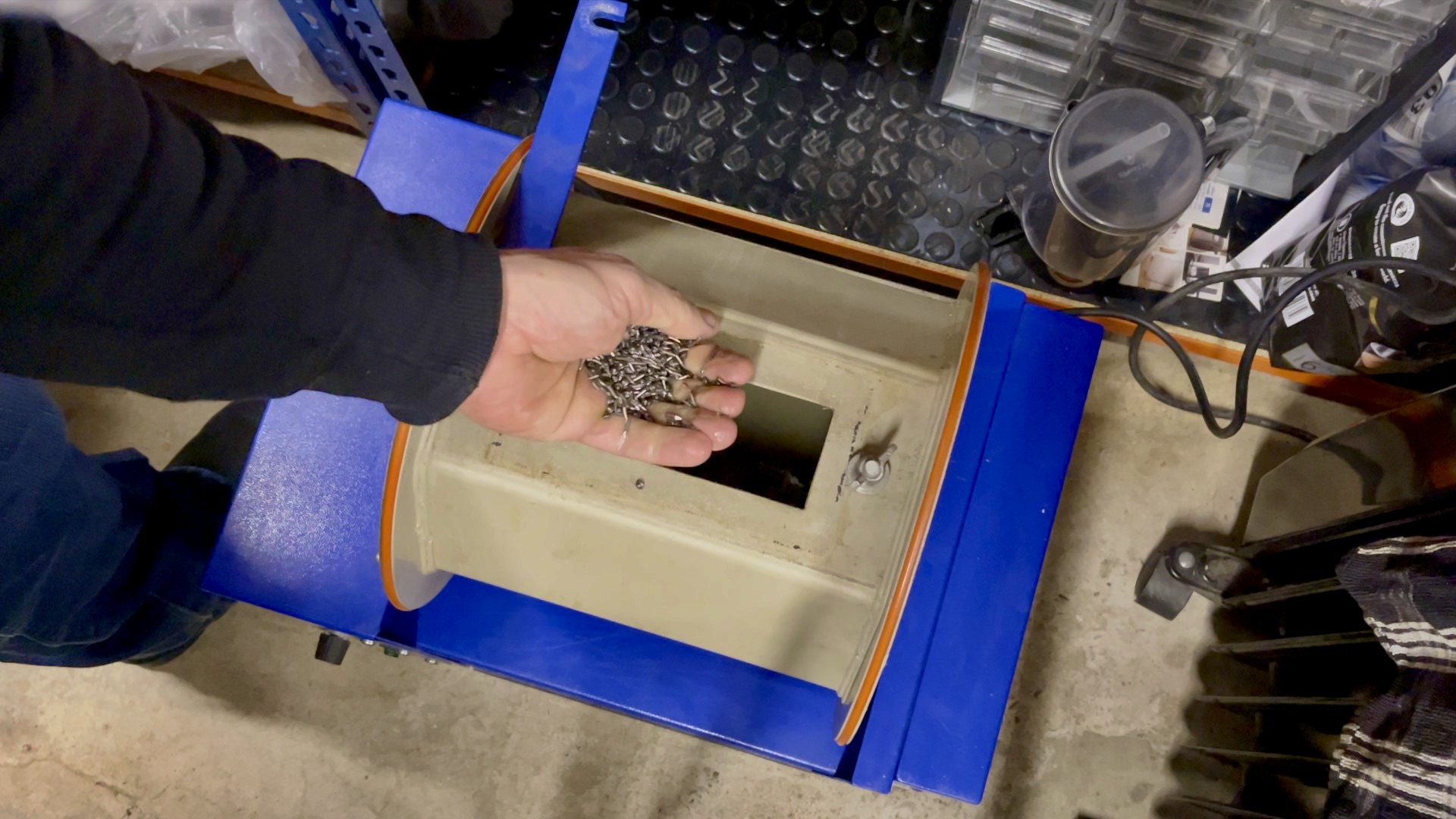 Stainless steel mixed shot inside a barrel polisher, used for brightening the silver charm.