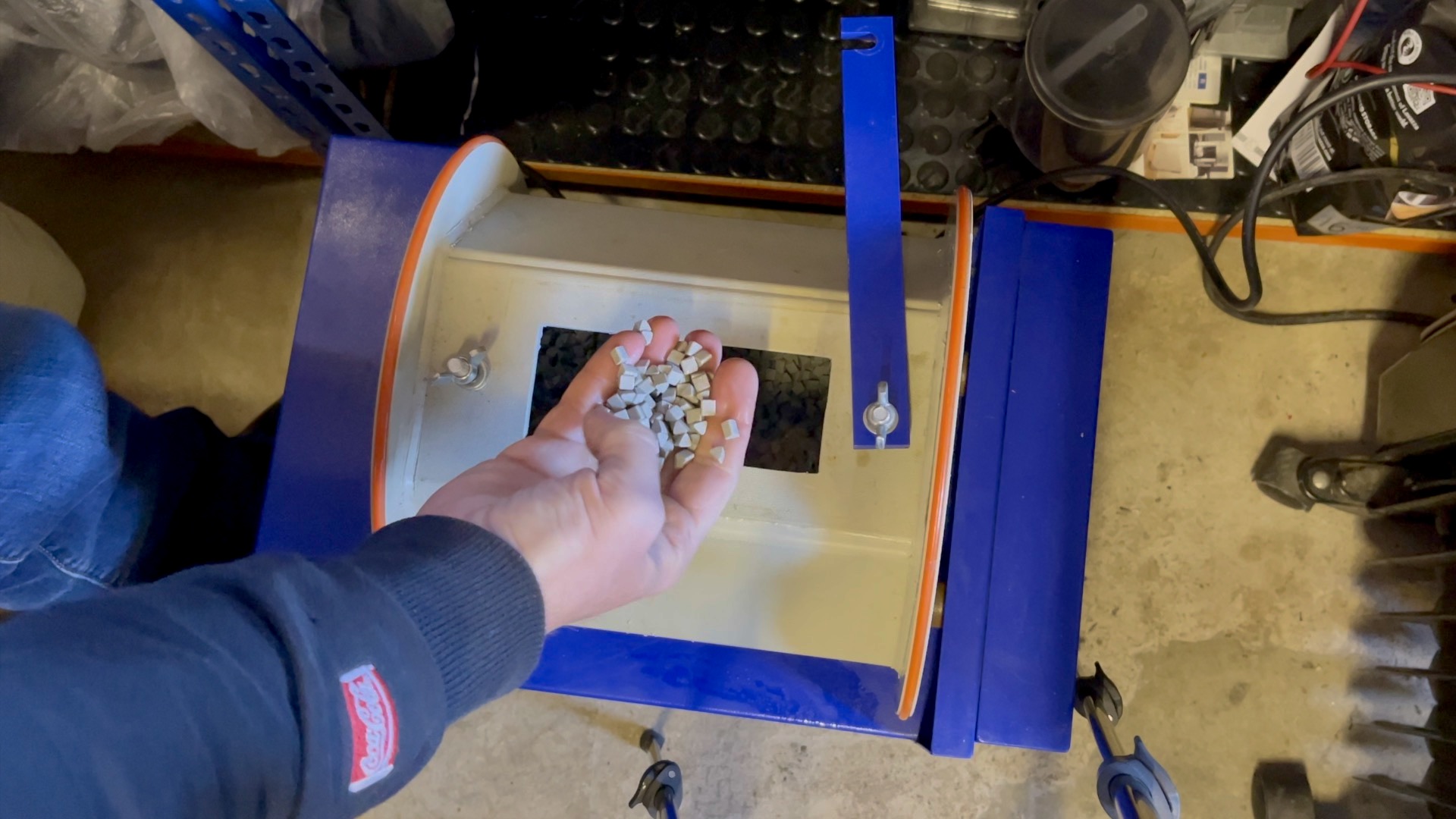 The heart charm inside a barrel polisher filled with ceramic media for smoothing.