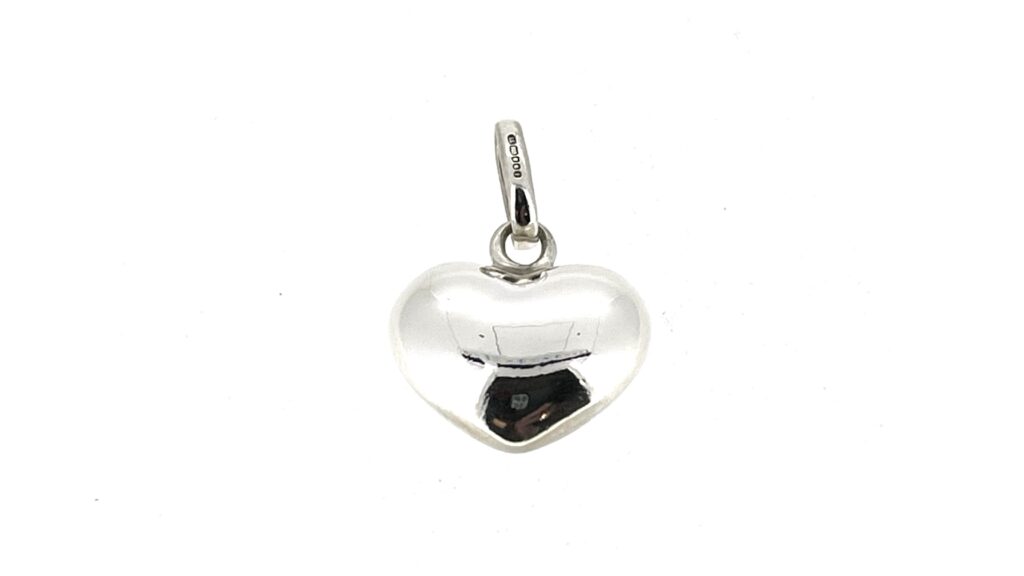 A magnified view of the restored heart charm showing its highly reflective surface.