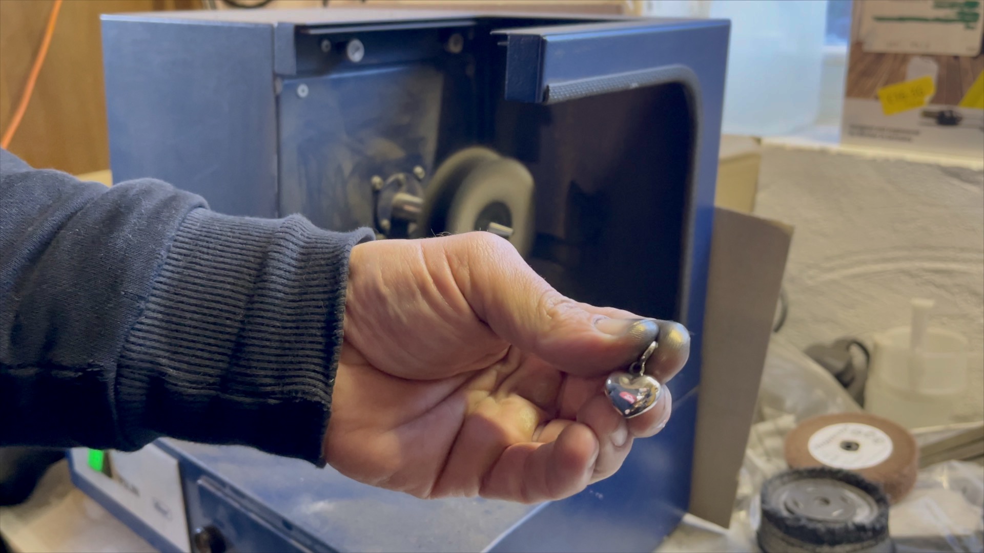 A jeweler holding the heart charm to highlight its size and three-dimensional design.