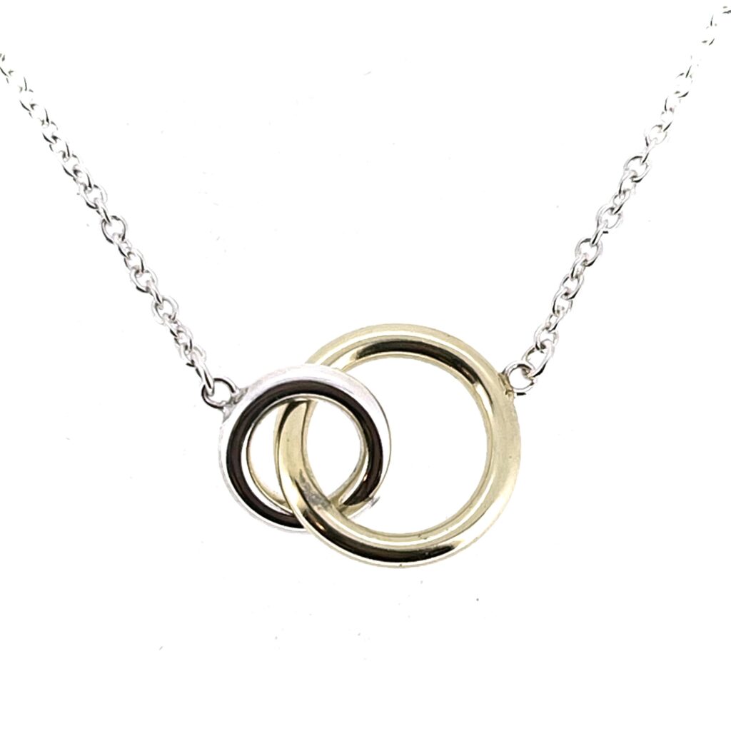 Close-up of interlocking yellow gold and silver rings
