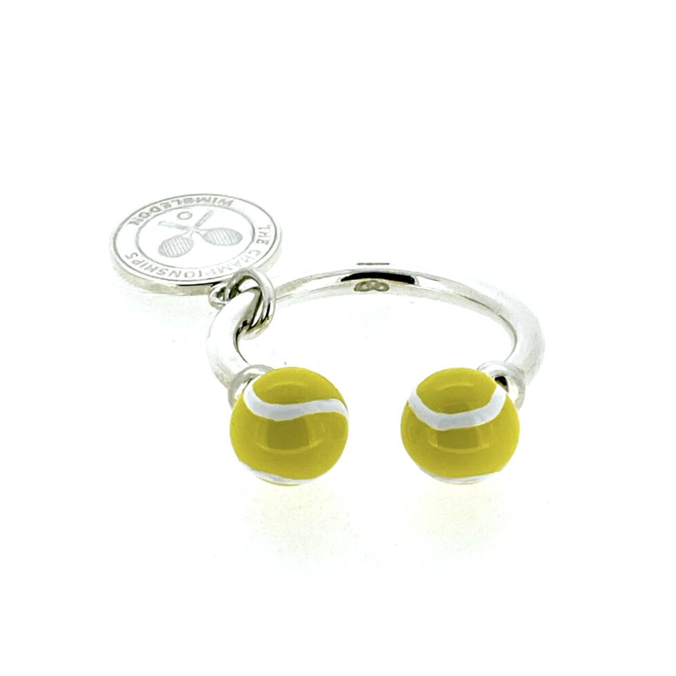Enamelled tennis ball and charm detail shown from an angle.