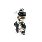 Close-up of enamelled scroll with red ribbon on bear charm
