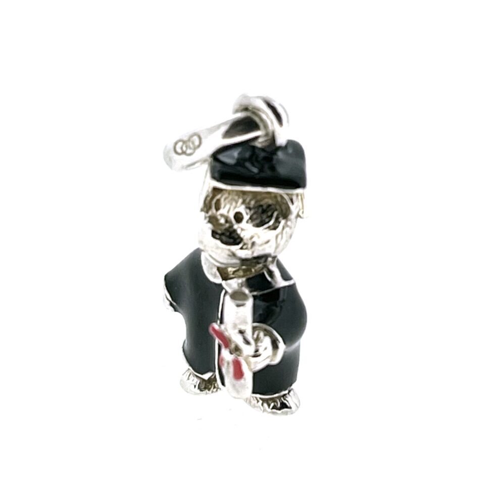 Close-up of enamelled scroll with red ribbon on bear charm