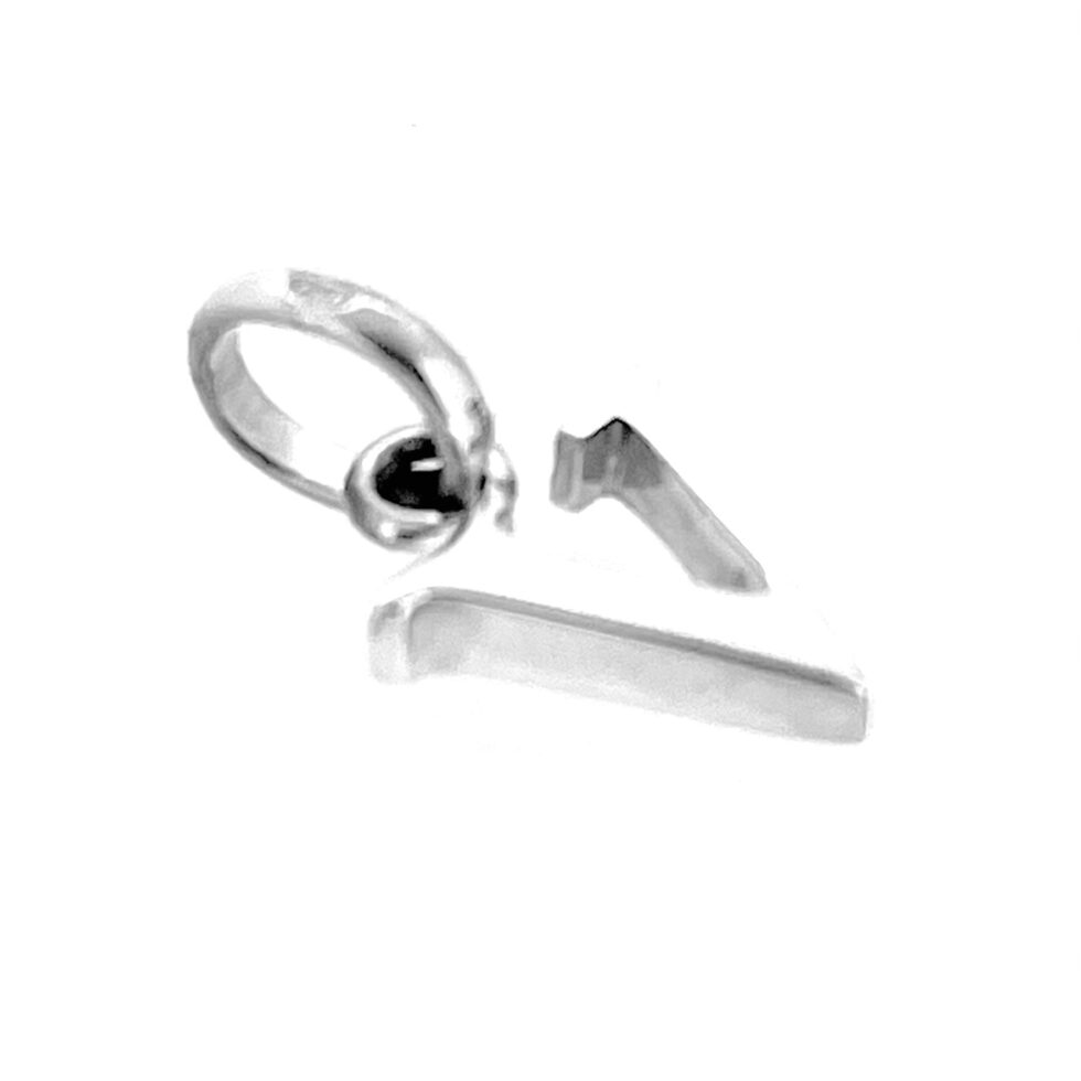 Close-up of serif V charm polished silver