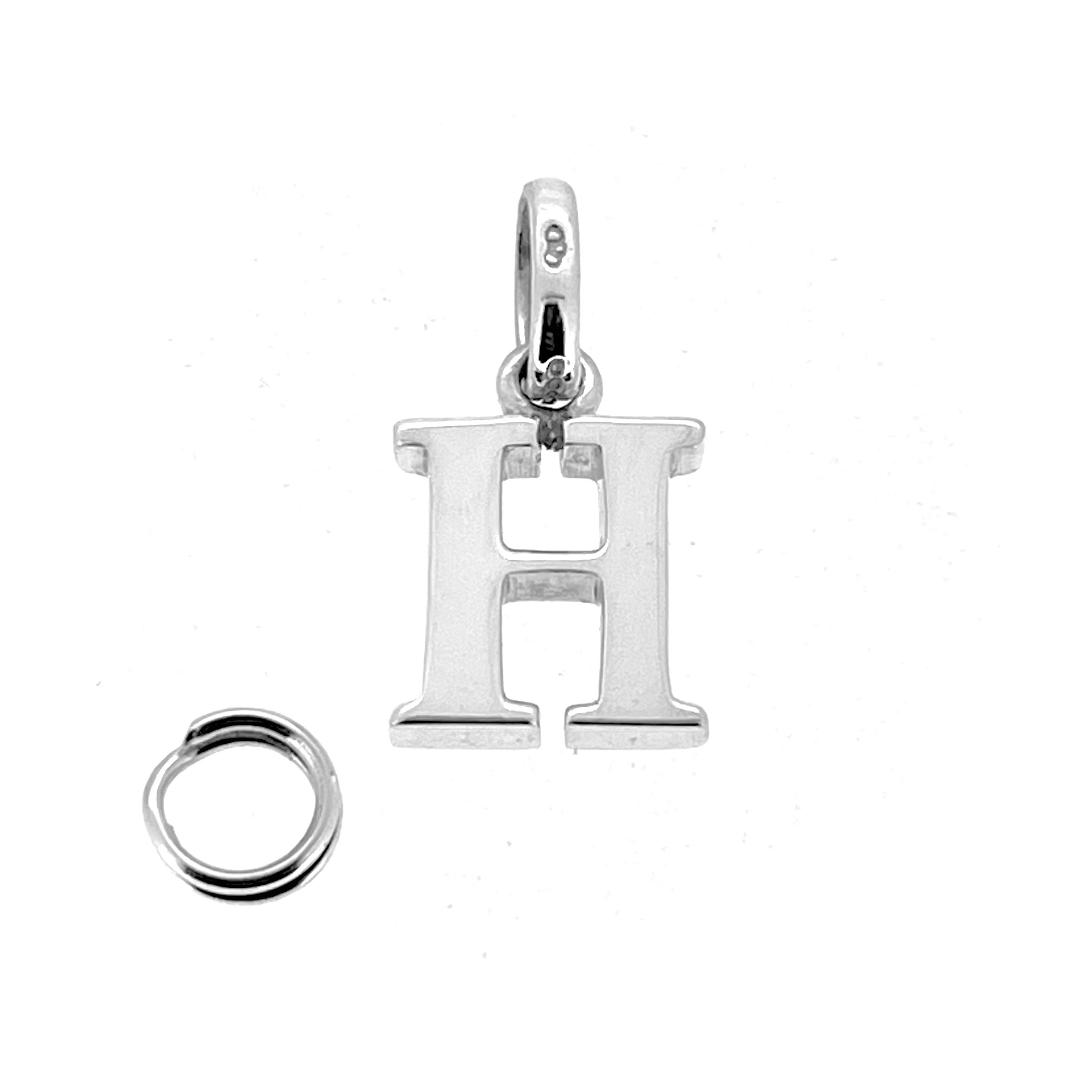 Polished vintage Links of London H charm on white background
