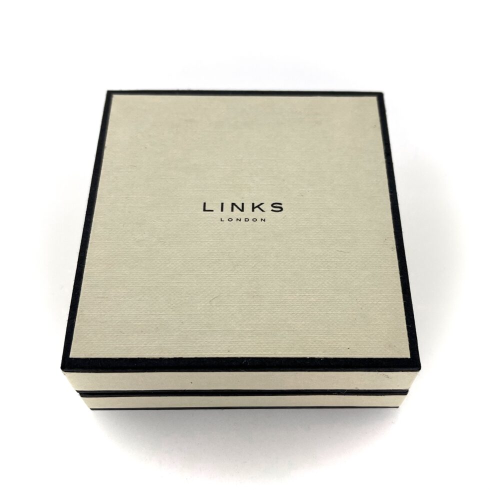 Cream and black Links of London box with logo on lid.