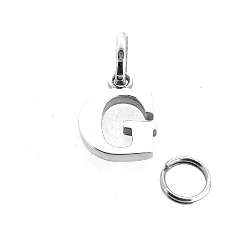 Close-up of polished silver Links of London G charm showing LL 925 hallmark and smooth finish.