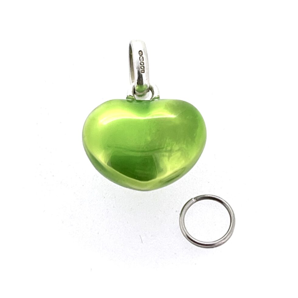 Green enamel heart charm on white background polished finish