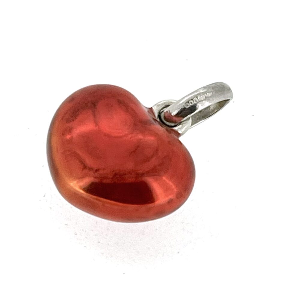 Close-up of translucent red enamel heart charm in sterling silver