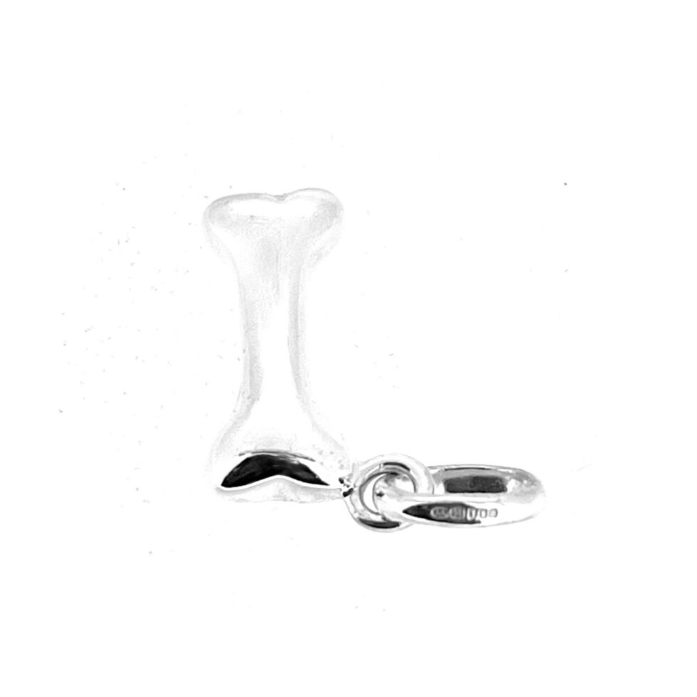 Angled view of vintage dog bone charm with standard oval bail