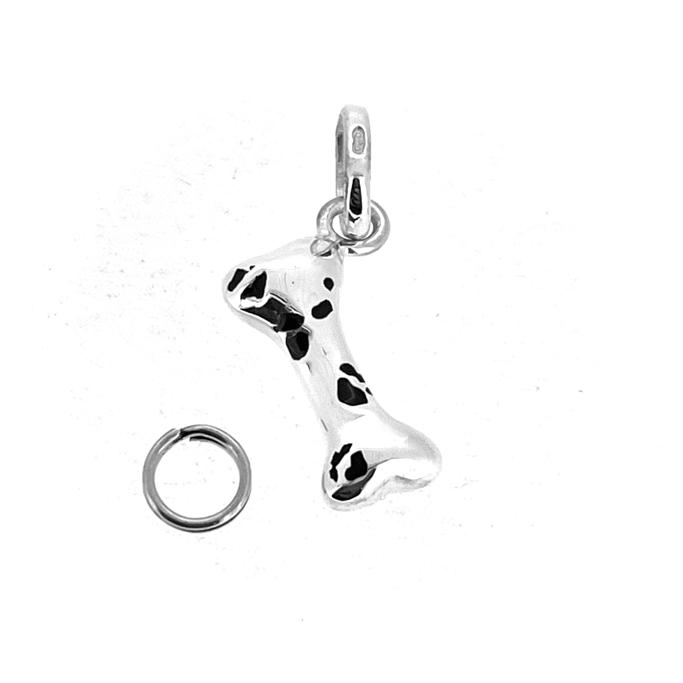 Side view of sterling silver dog bone charm showing black enamel patches