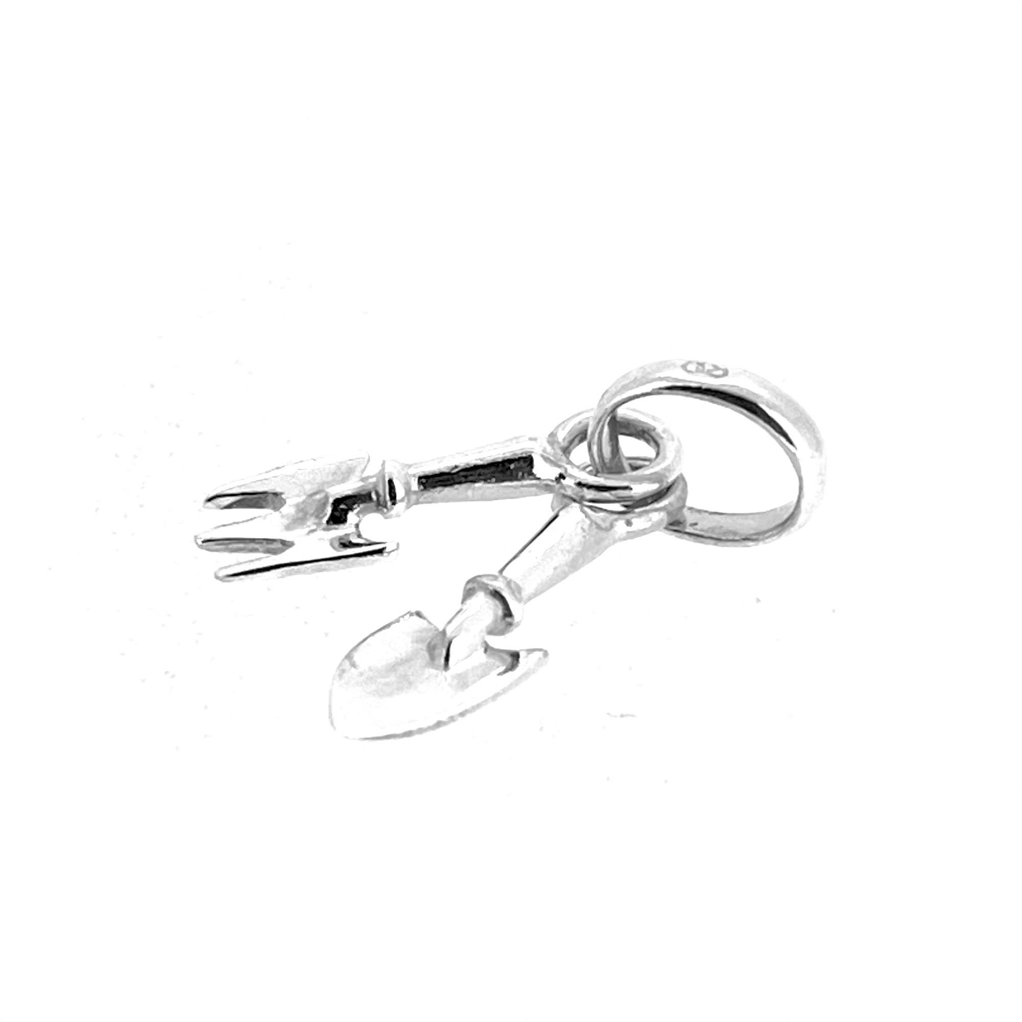 Angled view of vintage sterling silver gardening tools charm with oval bail