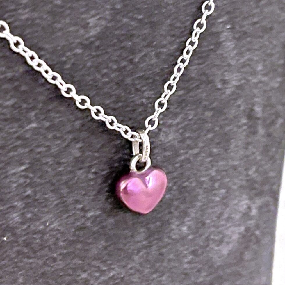 Side view of vintage Links of London mini heart necklace showing domed profile