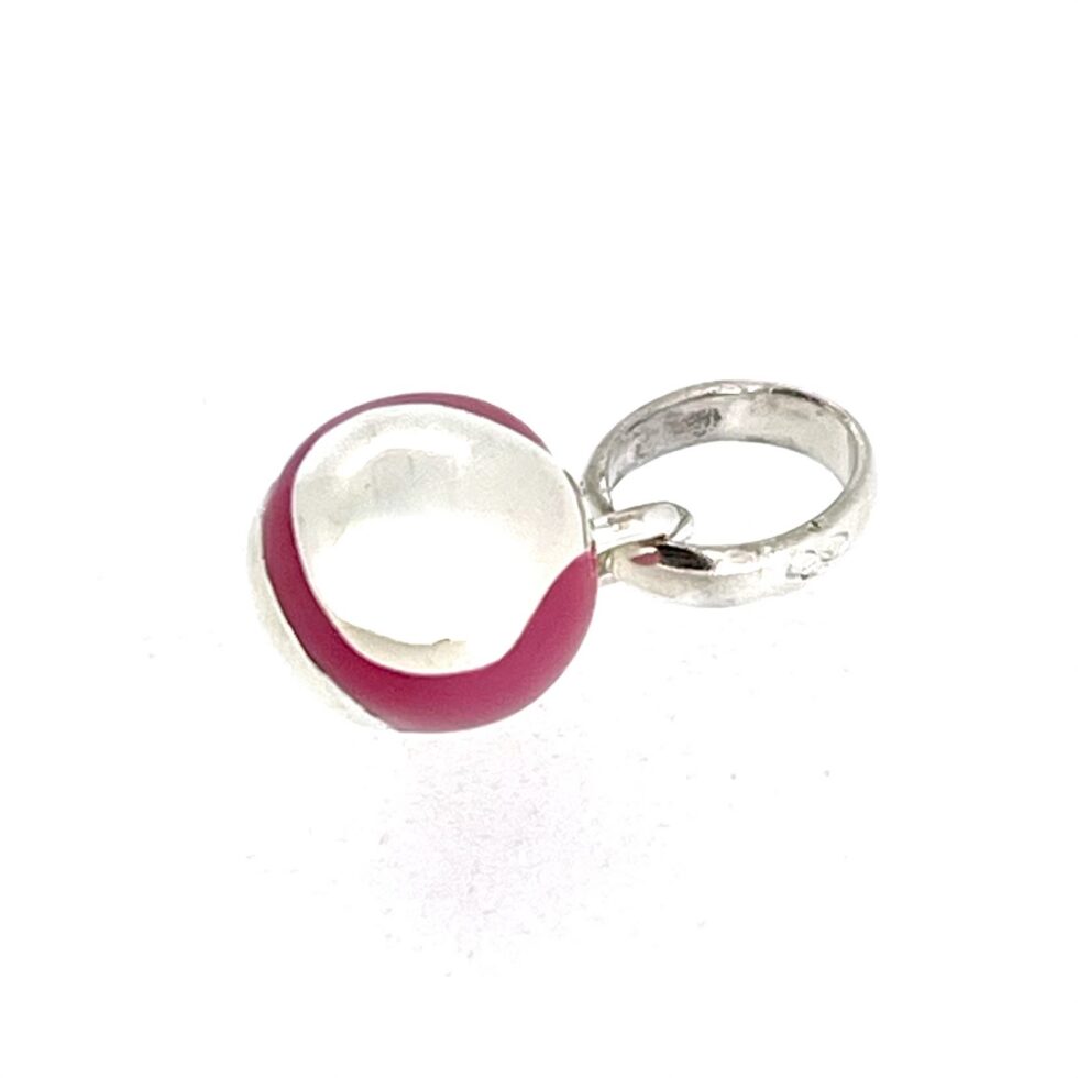Close view of curved tennis ball seam detail on silver and pink charm