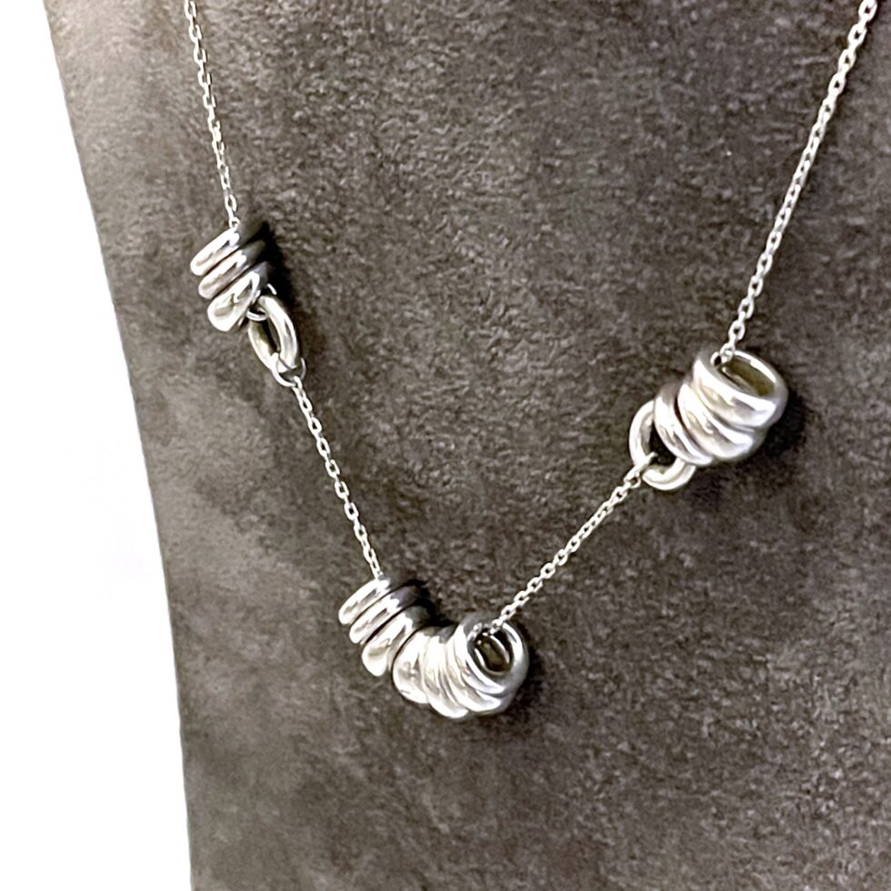 Front view of vintage Sweetie Links necklace on dark display stand