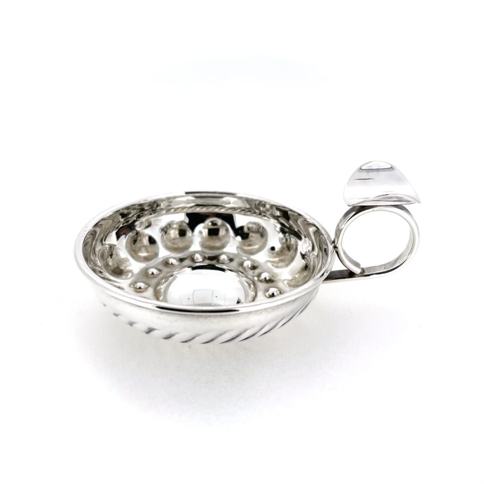Side view of vintage sterling silver tastevin showing shallow bowl form