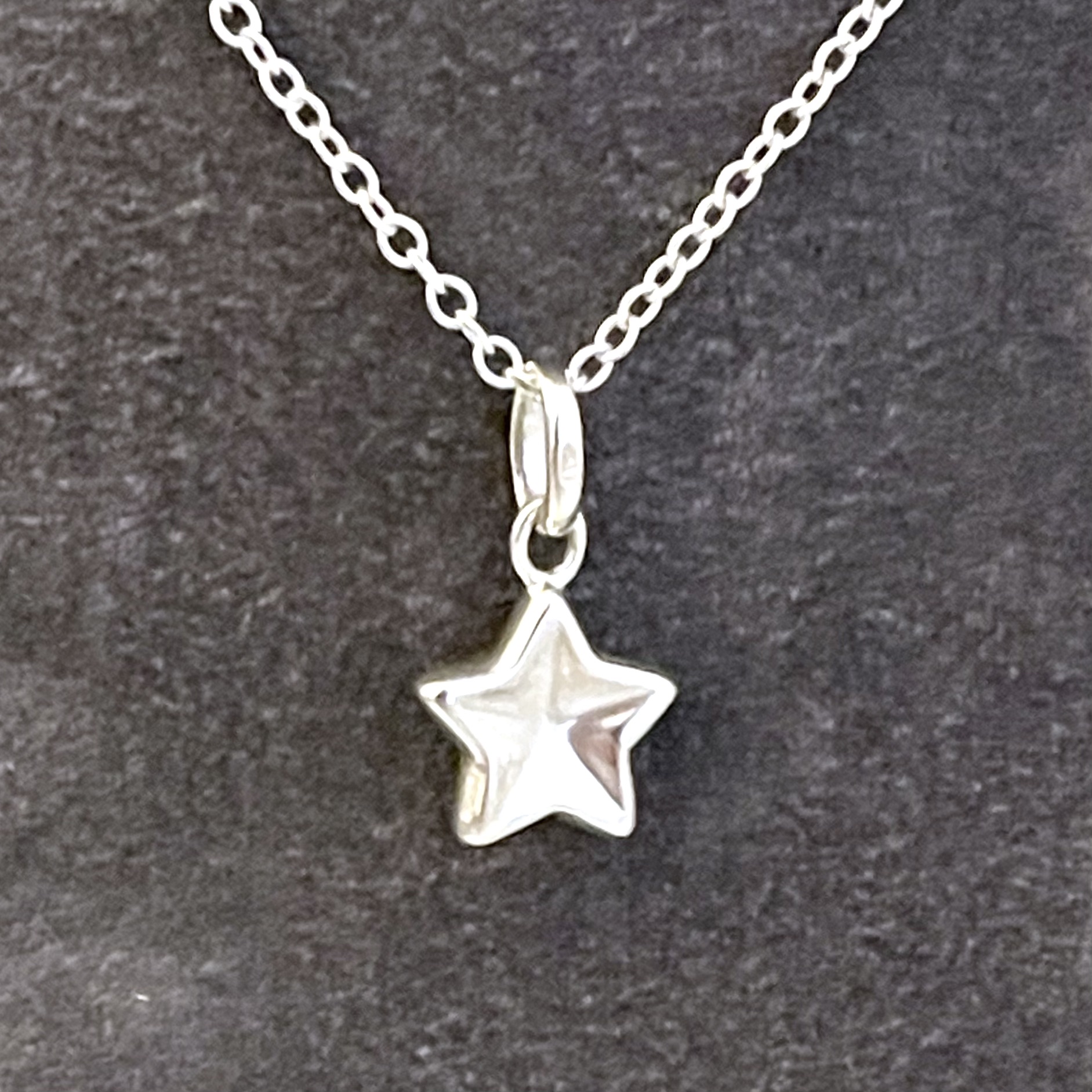 Sterling silver star necklace with softly curved sculptural profile front view